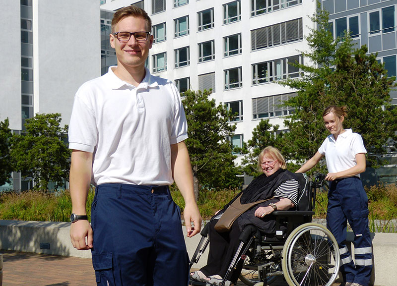 Fahrer unterstützt eine Person mit Behinderung bei der Beförderung in Hamburg